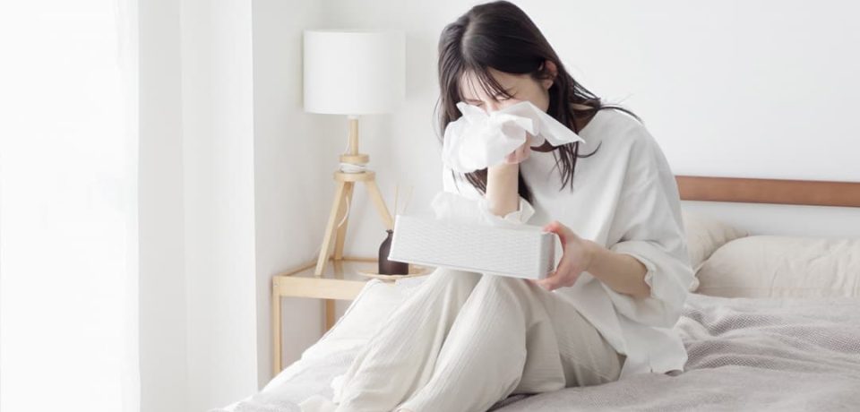 Woman experiencing sneezing and nasal irritation from allergic rhinitis
