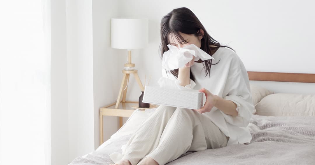Woman experiencing sneezing and nasal irritation from allergic rhinitis