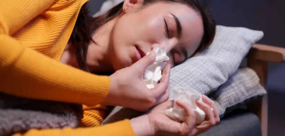 Young woman lying on the sofa at night, suffering from rhinitis Young woman lying on the sofa at night, suffering from rhinitis